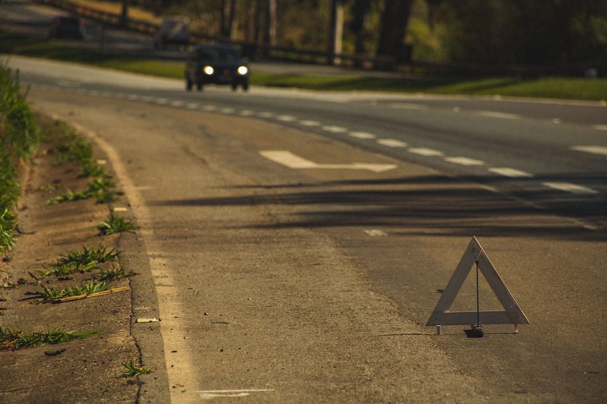 A warning triangle set up on a road at dusk