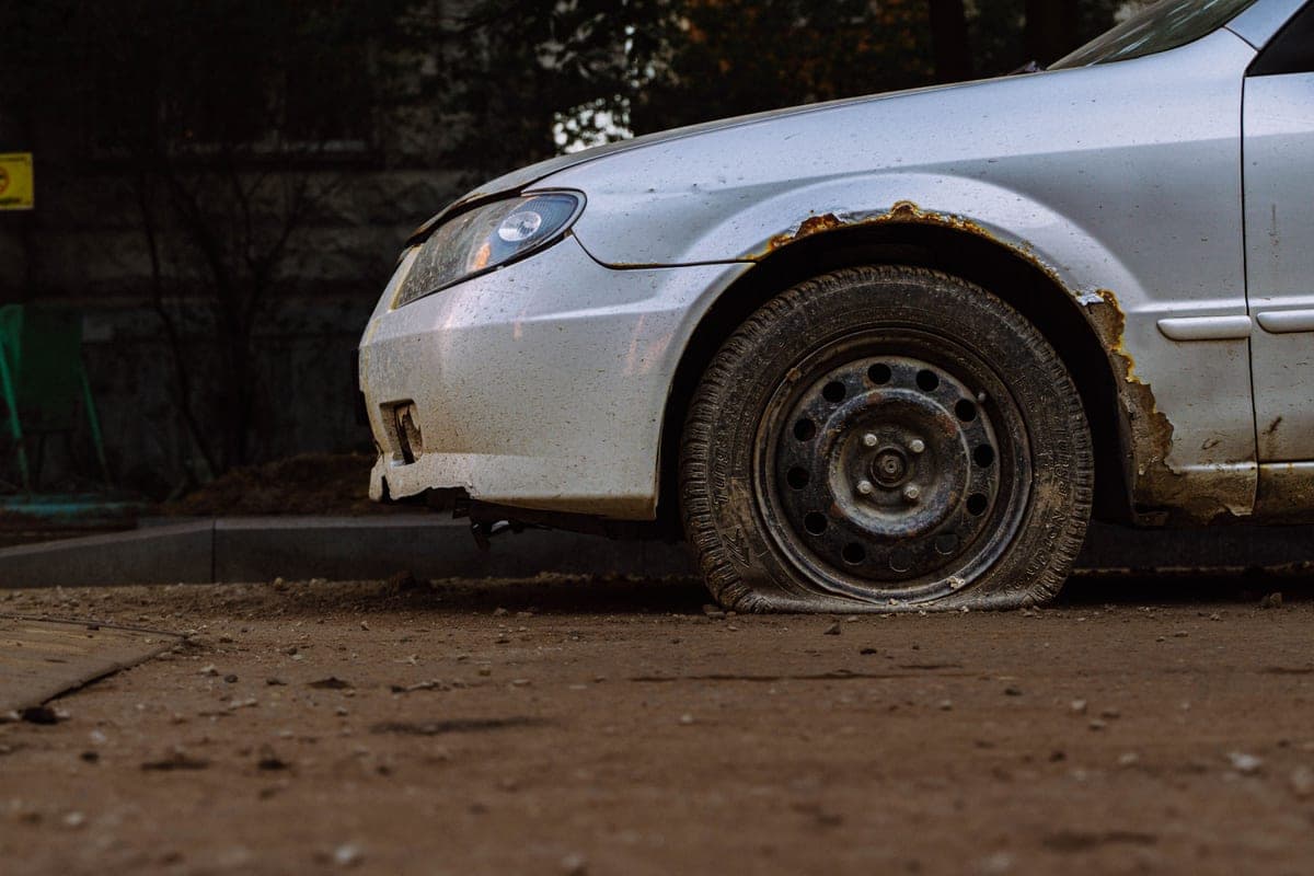 A car with a flat tire at the roadside
