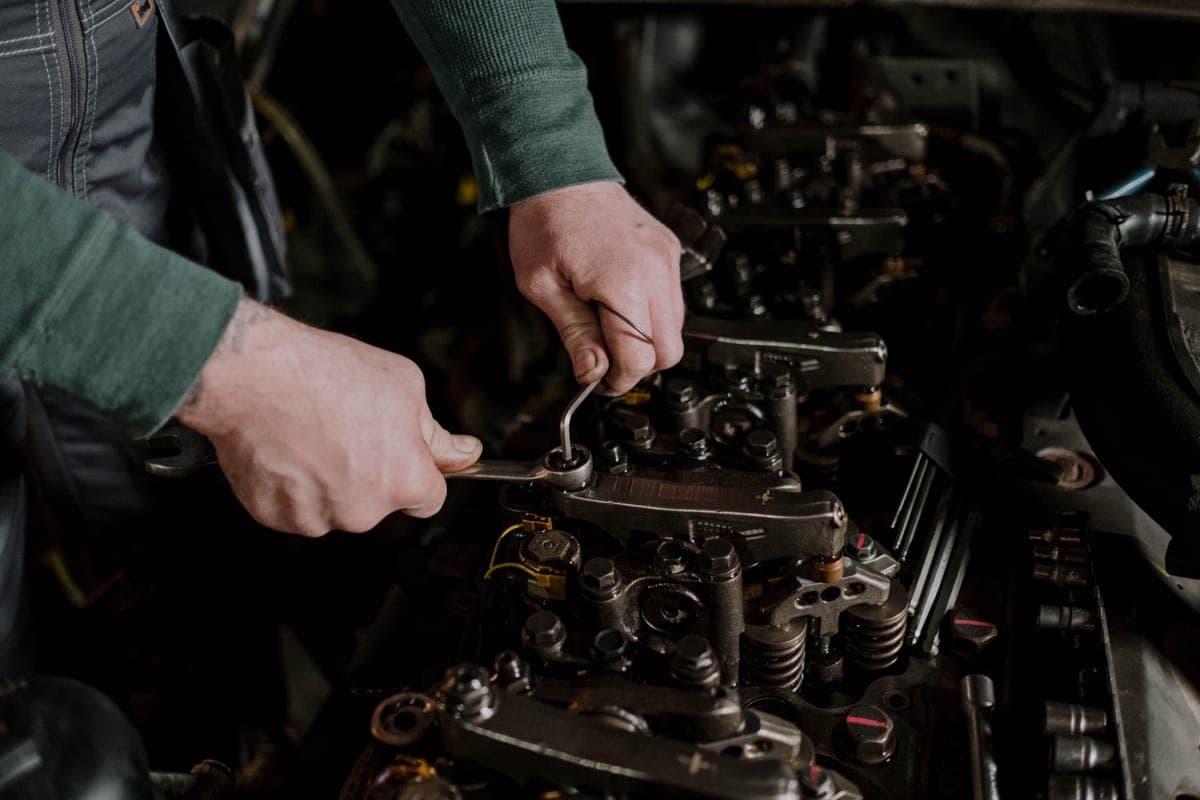 Hands working on machinery in a garage