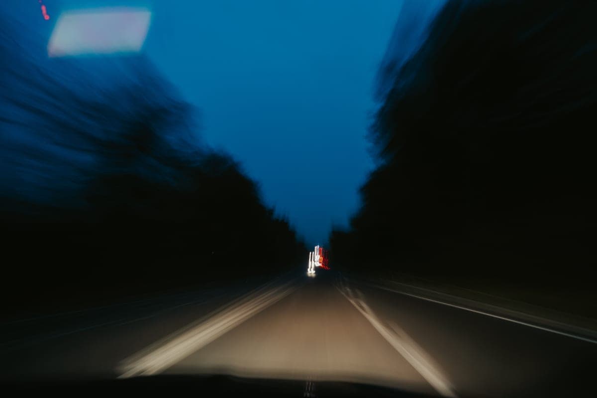 A road at night seen from inside a car