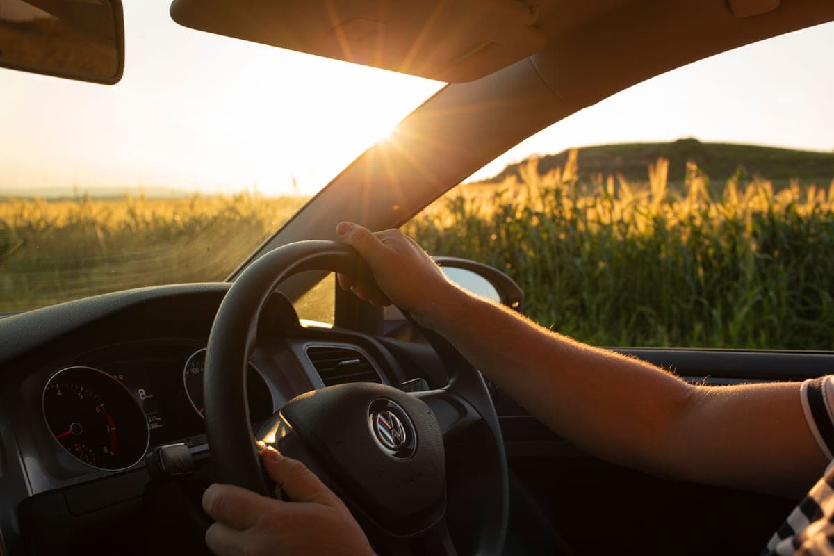 Driving into low sun on an open road