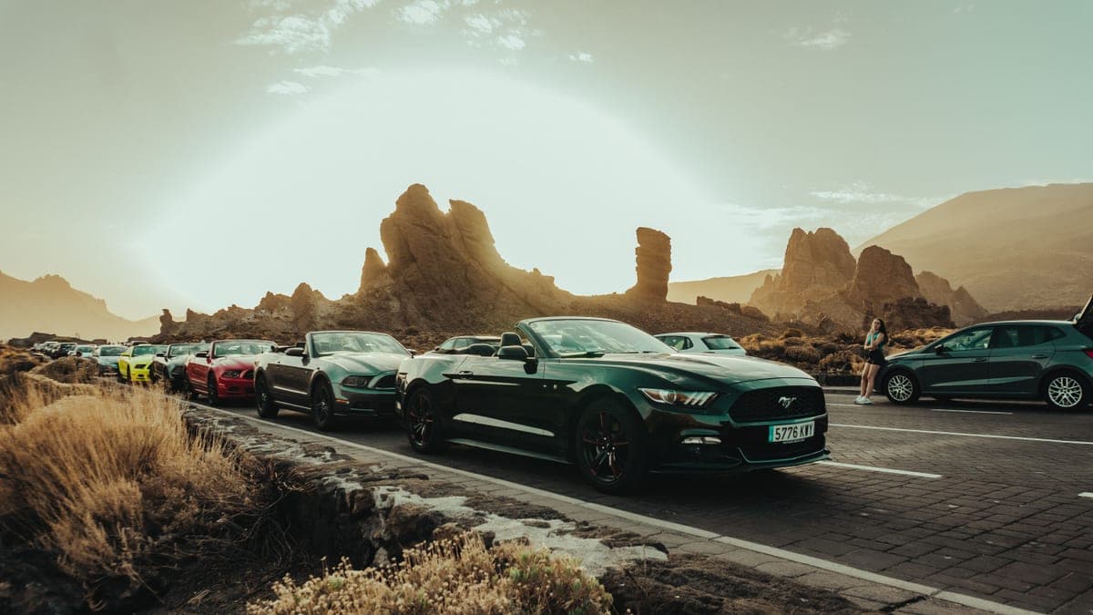 Cars on a desert highway with mountains in the distance